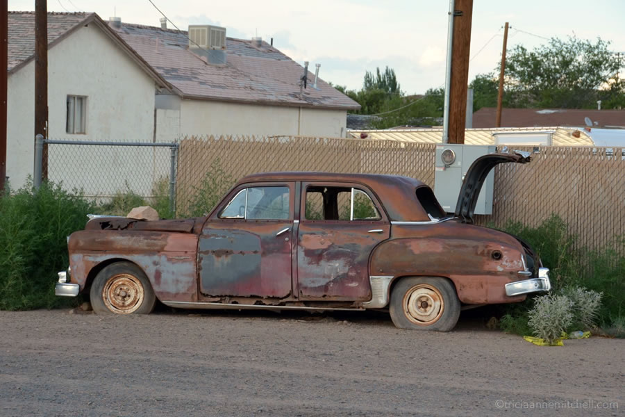 A rusted and abandoned car sits on the side of Route 66 in Holbrook, Arizona.