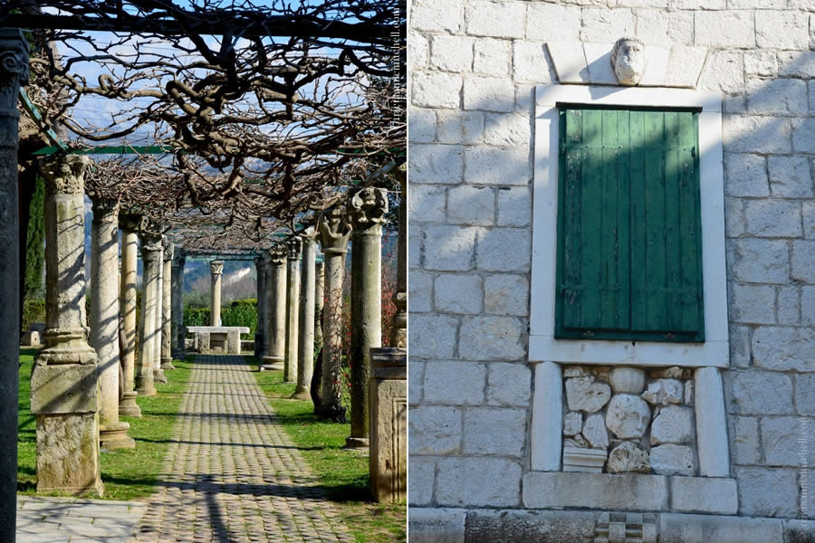 On the left is a colonnaded path next to Salona's Tusculum, topped with wisteria vines. On the right, mismatched fragments of ruins fill a niche underneath a window of Salona's Tusculum building. The green shutters are closed.