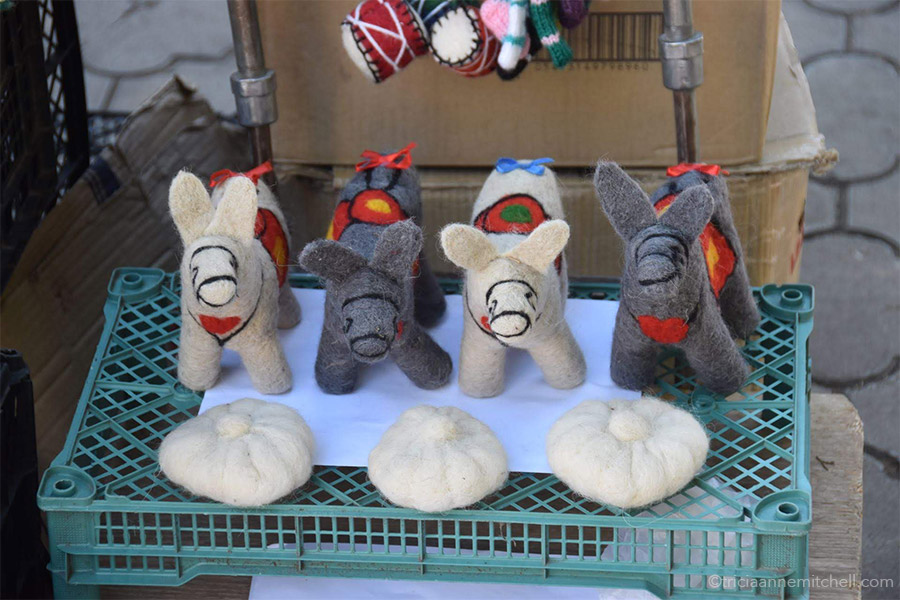 Four woolen donkeys, and three Georgian dumpling toys are displayed at an outdoor market in the town of Sighnaghi.